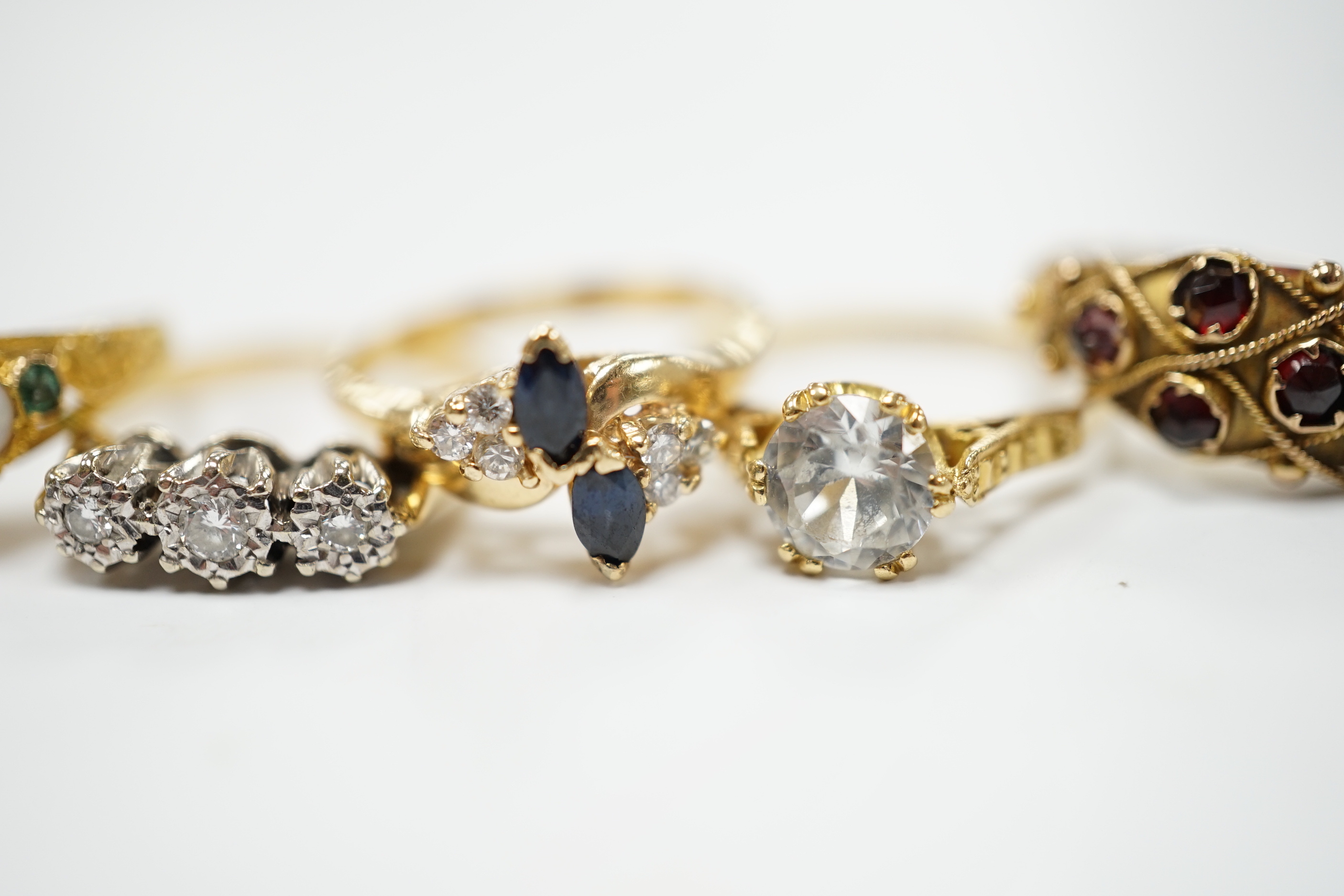 An Edwardian 15ct?, white opal, emerald and amethyst cluster set ring, in the Suffragette colours, size F, together with four other yellow metal and gem set rings including three stone illusion set diamond and a 14k sapp